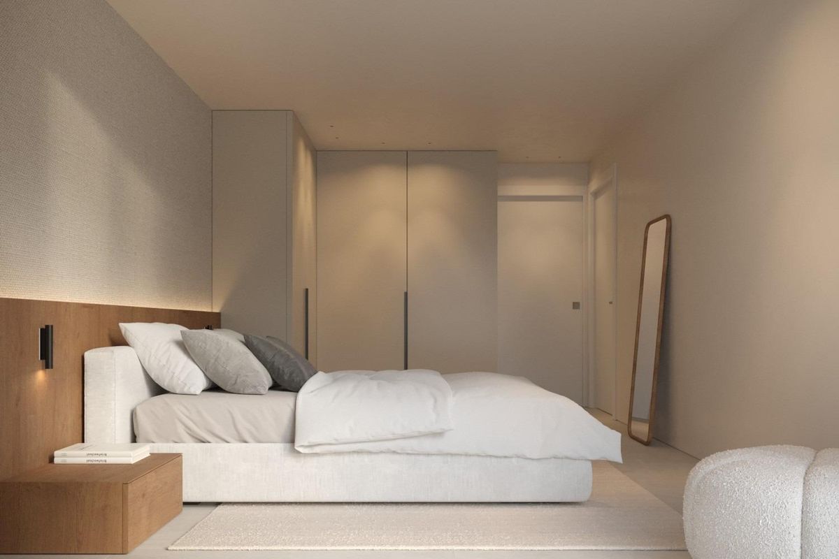 Rustgevende slaapkamer met wit bed, houten accidentwand, ingebouwde kledingkast en zachte sfeerverlichting in neutrale tinten