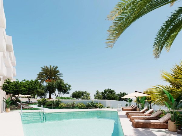 Zwembad met palmbomen in Mijas, Costa del Sol, omringd door ligstoelen en groene planten.