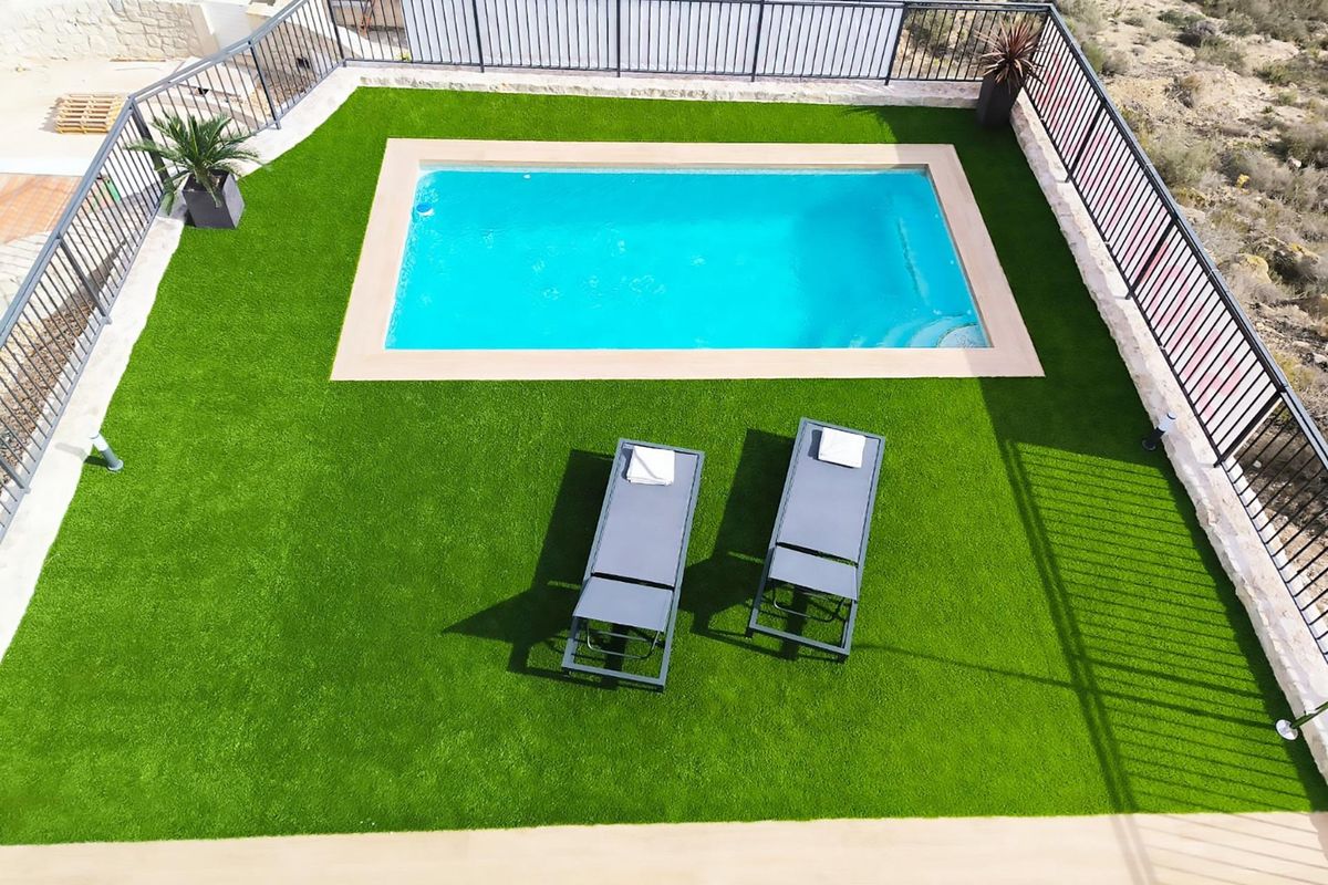 Luchtfoto van het zwembadgebied en ligstoelen in mooi aangelegde tuin in Algorfa, Costa Blanca Zuid, Spanje.