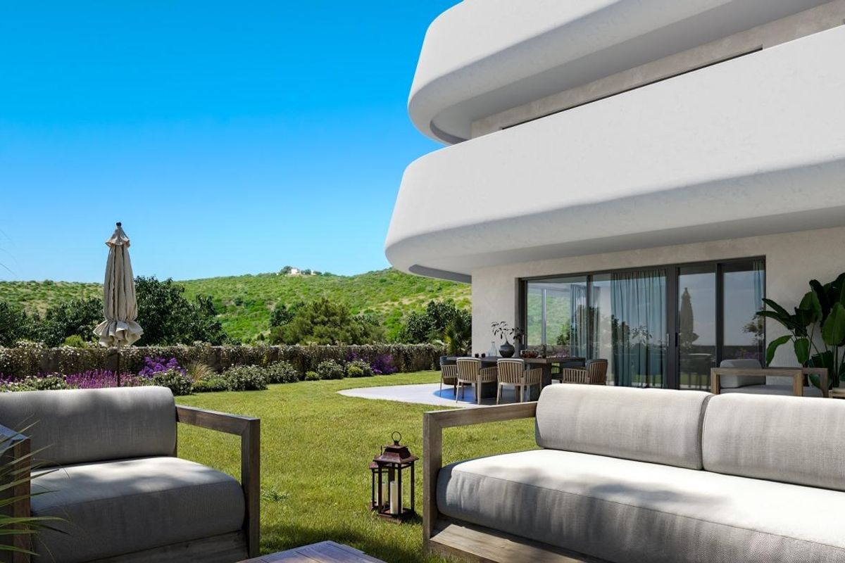 Gezellig terras met zitplaatsen met uitzicht op tuinen, verbonden met een modern appartement op de begane grond in Casares.