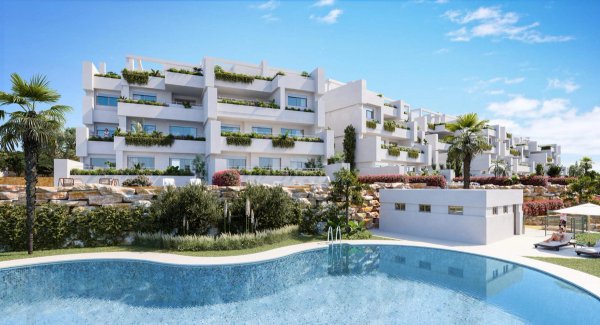 Buitenkant van een modern appartementencomplex in Estepona, met zwembad en aangelegde tuinen.