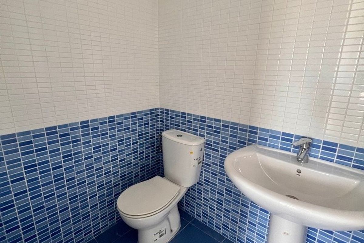 Helder blauw betegeld toilet in een penthouse in Calpe met een toilet en wastafel.