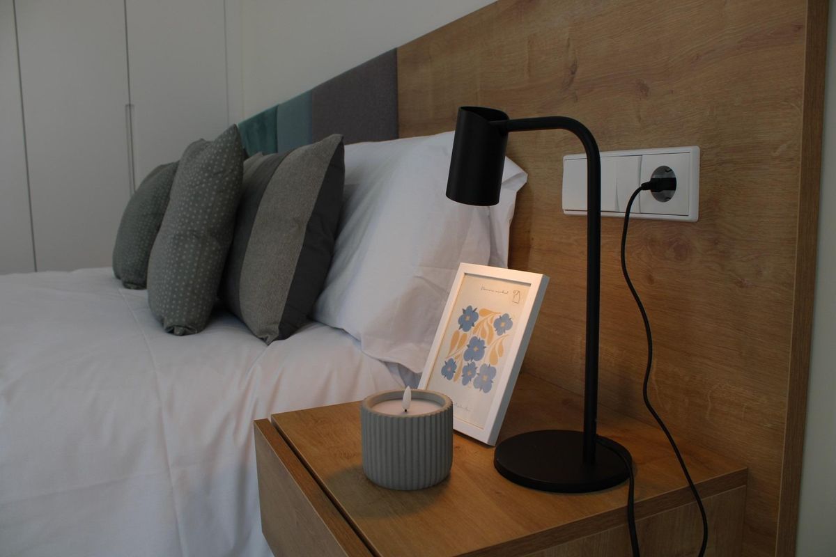 Moderne nachtkastje met een kaars en lamp in een stijlvolle slaapkamer van een 3-slaapkamer villa in Pilar de La Horadada.