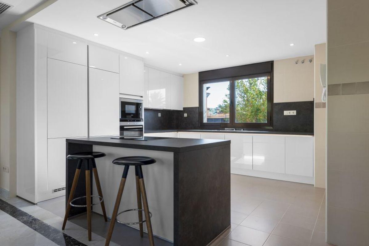 Chique keukeneiland en zithoek in een lichte ruimte van een villa in Estepona, ideaal voor casual dineren.