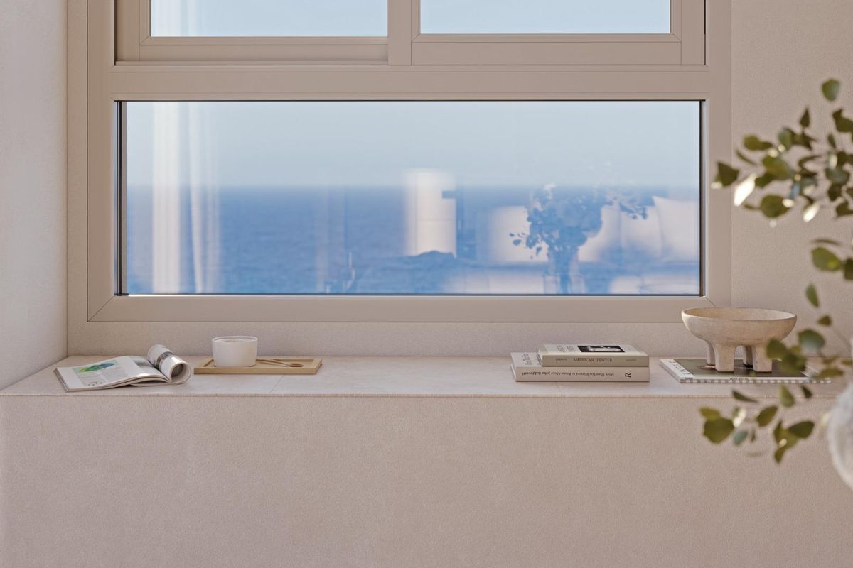 Serene window view showcasing the ocean and artistic decorations in this stylish Calpe apartment.