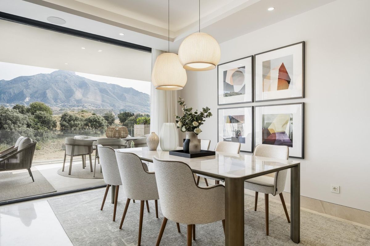 Eetkamer met een tafel voor zes, met uitzicht op de bergen door grote schuifdeuren in Marbella.