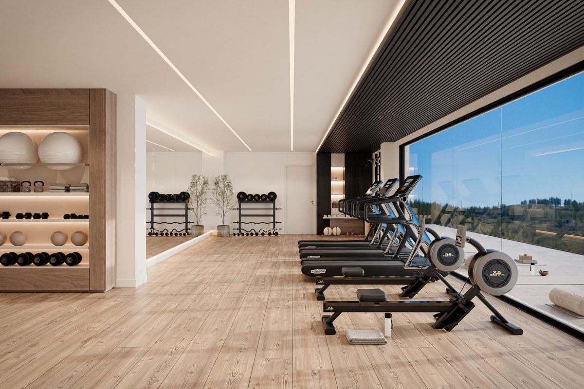 Heldere fitnessruimte in een 3-slaapkamer penthouse, uitgerust met moderne machines en uitzicht op Marbella.