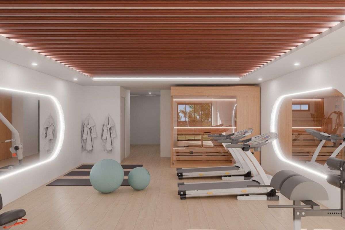 Moderne gymzaal in de townhouse, met fitnessapparatuur en grote spiegels, gelegen in Mijas, Spanje.