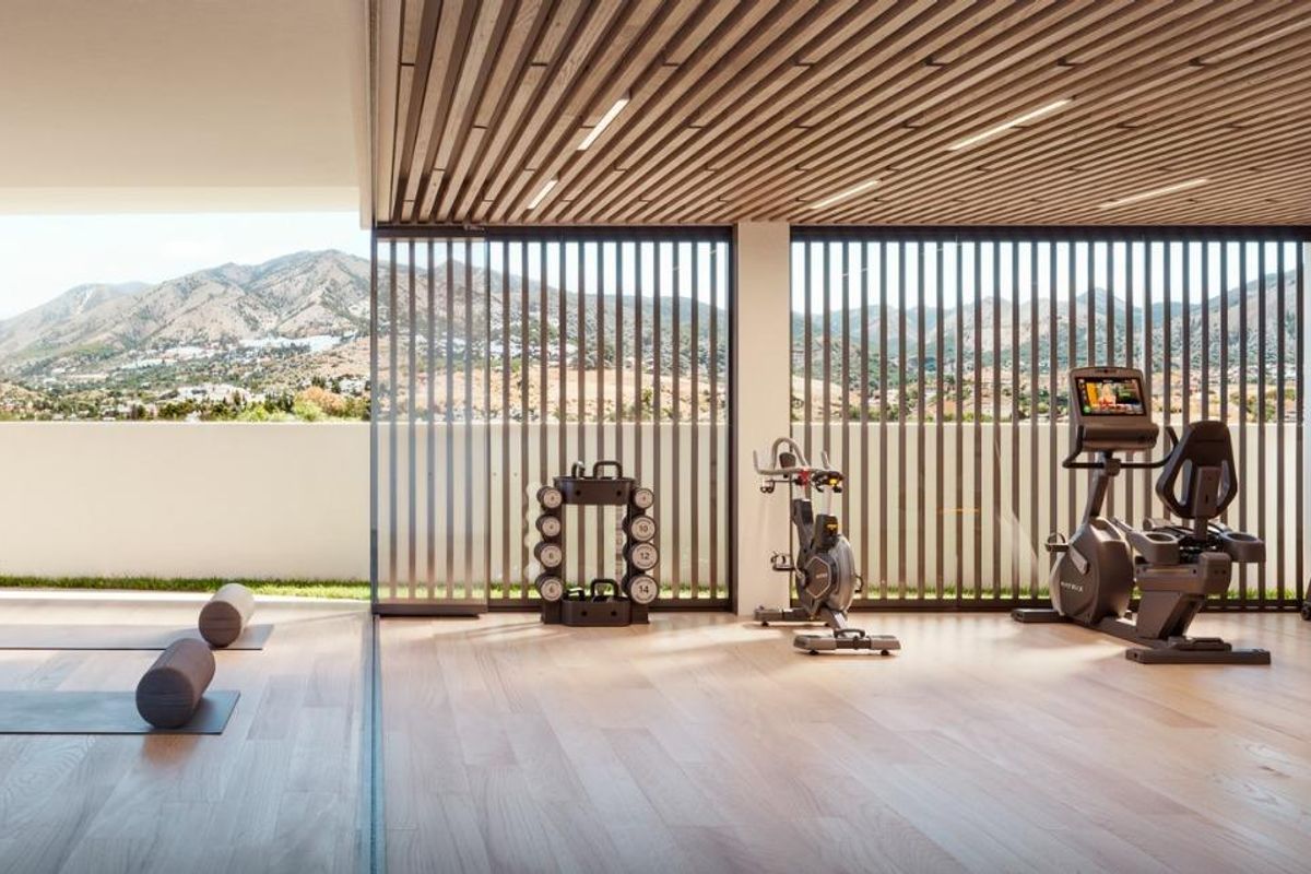 Moderne fitnessruimte met gymapparatuur en uitzicht op de bergen in een luxe gebouw in Fuengirola.