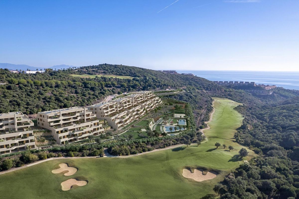 Luchtperspectief dat moderne appartementen en landschap in San Roque, Costa del Sol, toont, grenzend aan groene ruimtes.