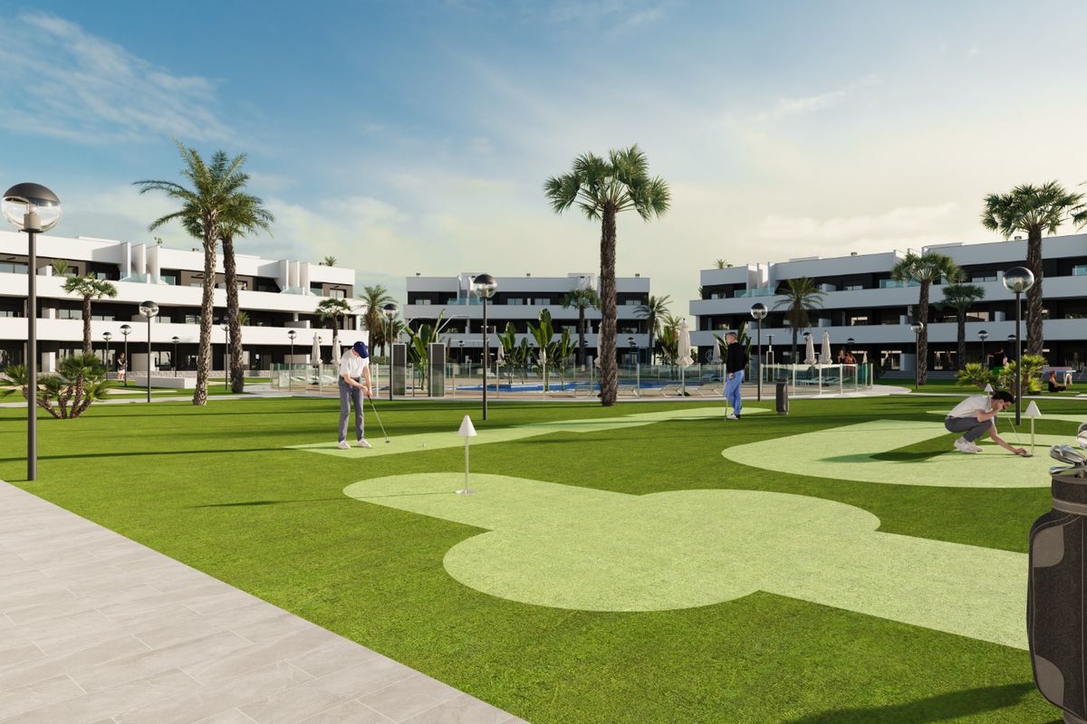 Gemeenschappelijke putting green met palmbomen en appartementscomplex op de achtergrond in Costa Blanca