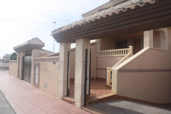 Buitenkant van een 2-slaapkamer huis in Torrevieja, met een uitnodigende ingang en betegeld pad.
