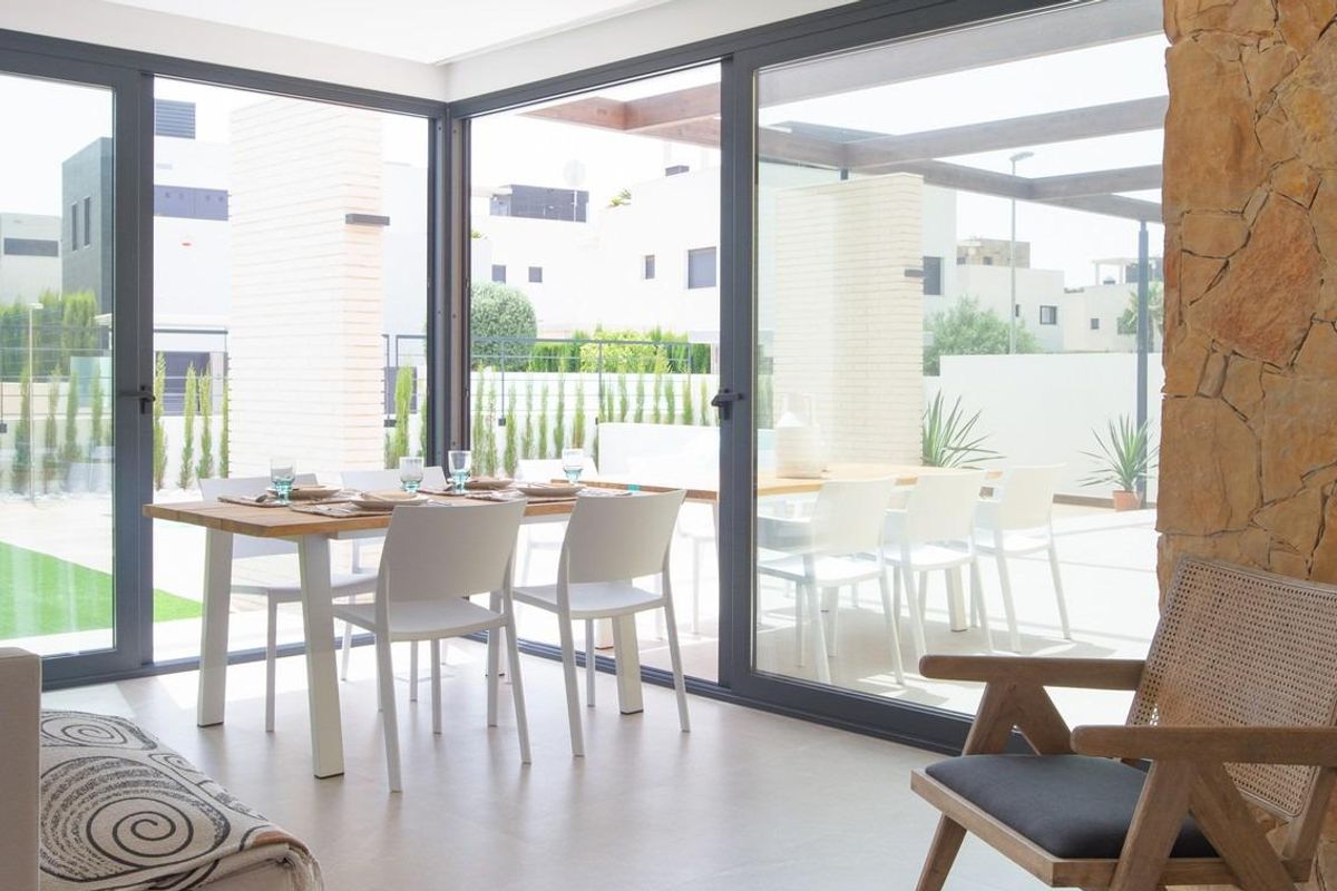 Heldere zithoek naast de eetkamer, met grote ramen in een villa in Orihuela Costa.