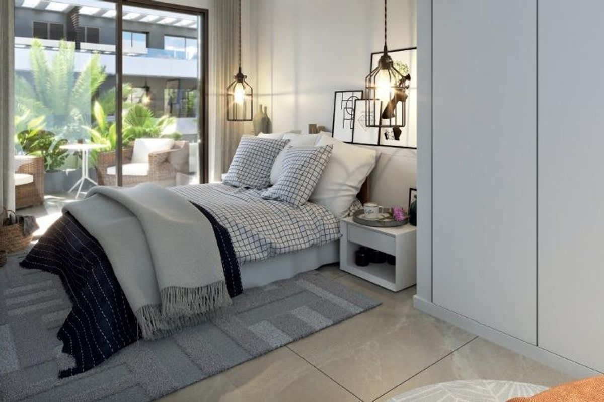 Stijlvolle slaapkamer met moderne meubels en toegang tot de tuin in een tweekamerappartement in San Juan Alicante.