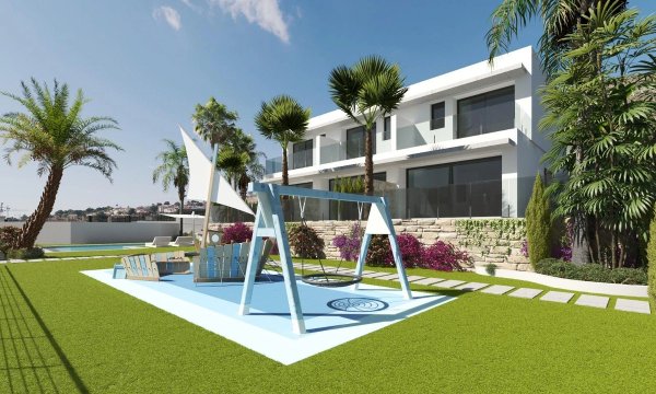 Ruimtelijke tuin met palmbomen en een schommel bij een 3-slaapkamer townhouse in Finestrat, Costa Blanca Noord.