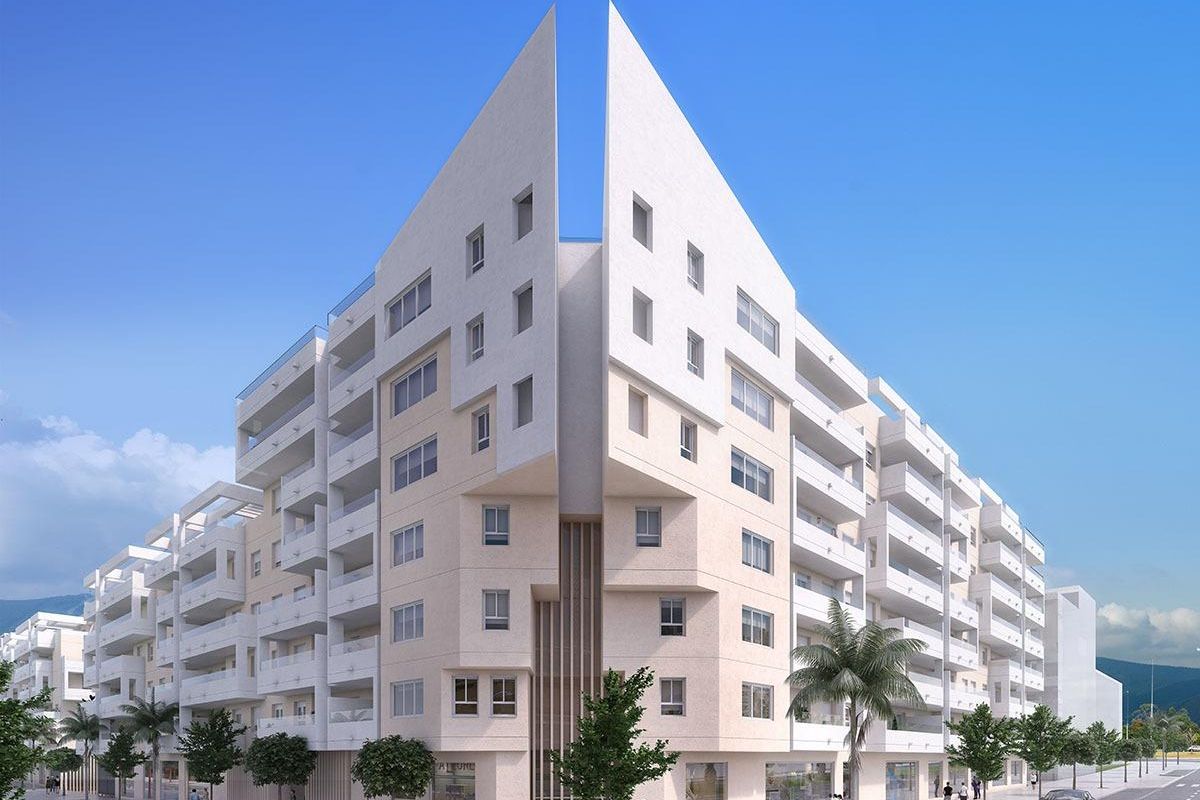 Stijlvol hoekzicht van een appartementencomplex in Marbella met witte gevels en groen rondom.