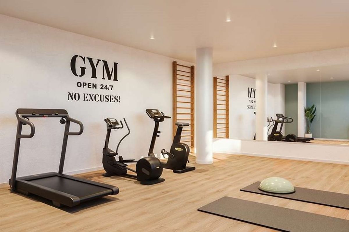 Goed uitgeruste gym in een penthouse complex in Denia, met moderne fitnessapparatuur en heldere verlichting.