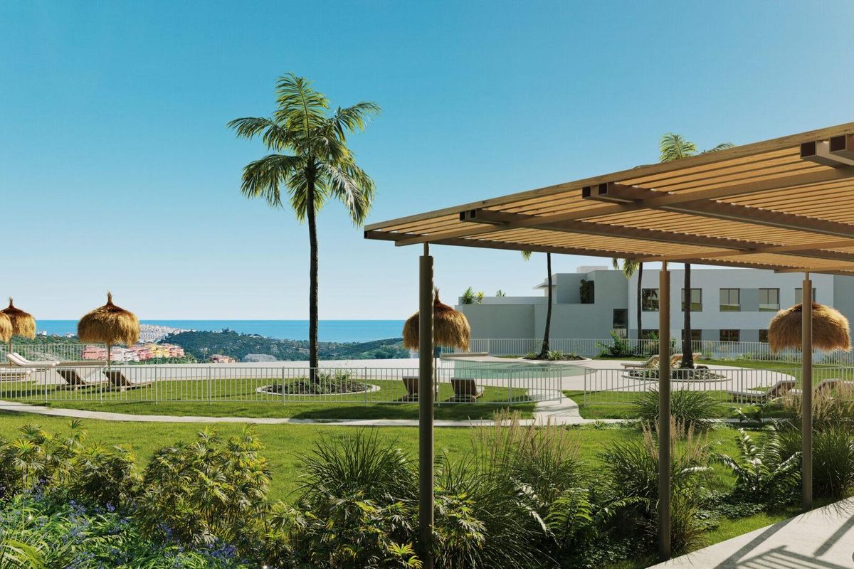 Uitzicht op de aangelegde tuin en het zwembadgebied in Casares, Costa del Sol, omringd door palmbomen.