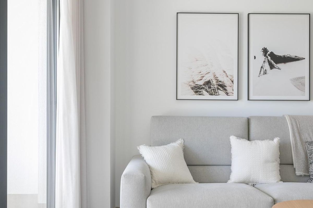 Gezellige hoek van de woonkamer met een bank en kunst, die naar een terras leidt in Torrevieja.