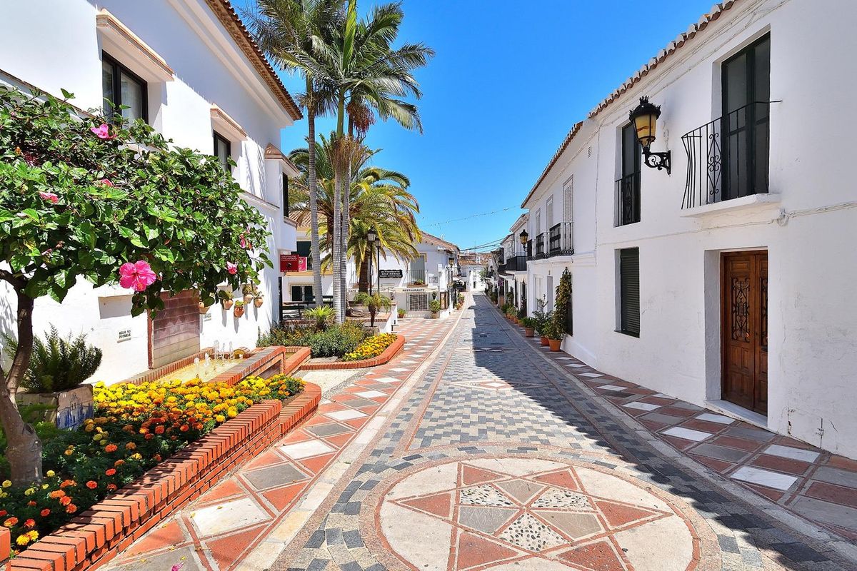 Charmante straat in Benalmádena met bloemendecoraties, die lokale architectuur laat zien.