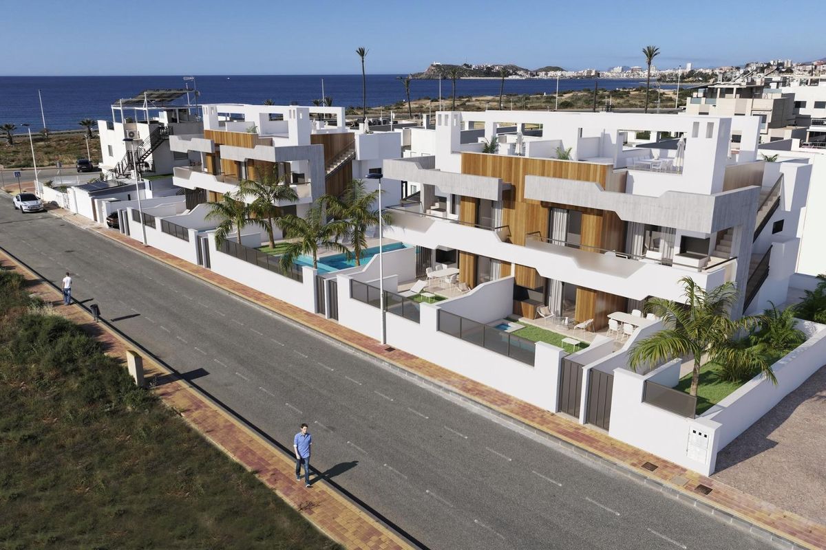 Luchtfoto van een stijlvol appartementengebouw met patio's en zwembaden, gelegen in Puerto de Mazarron, Spanje.