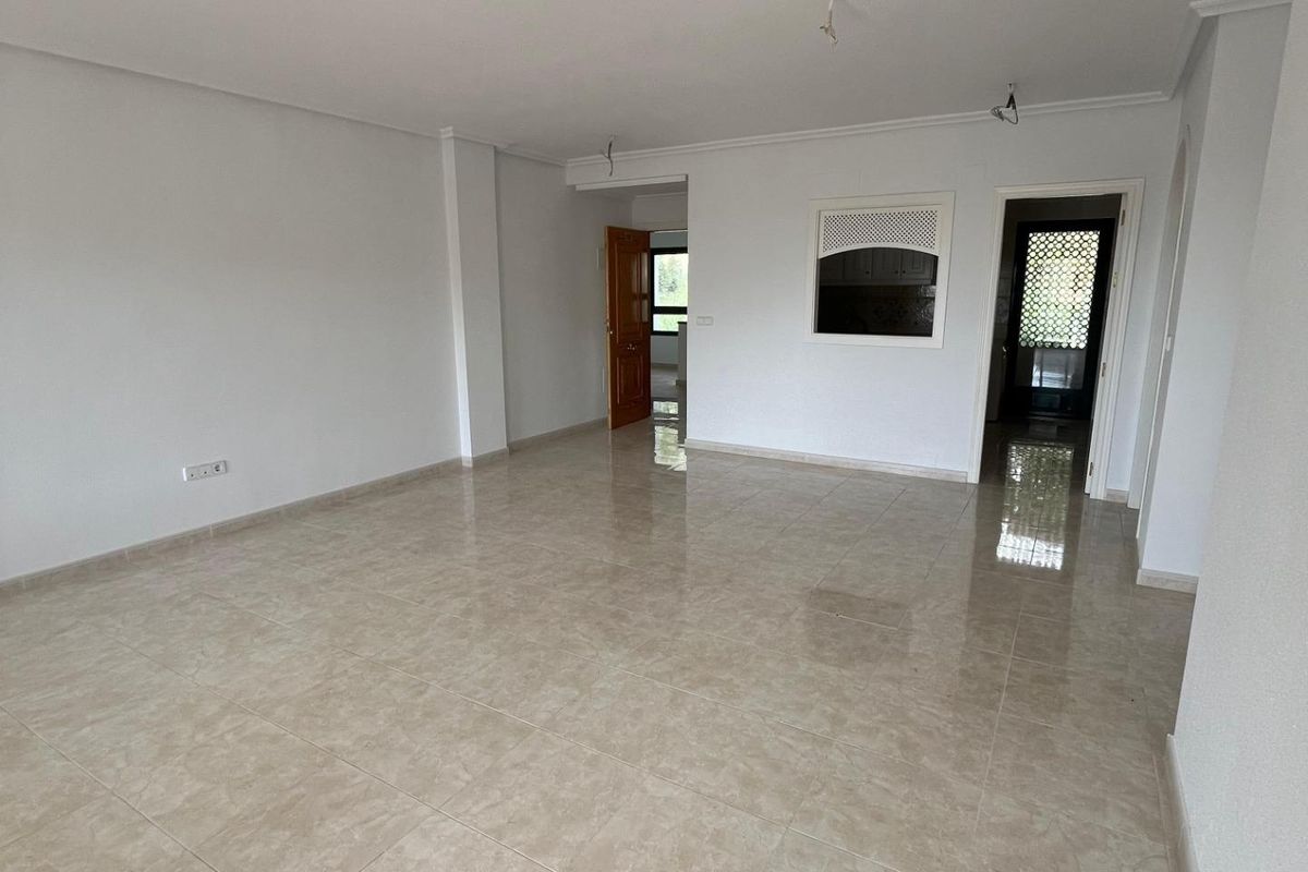 Open indeling van de woonkamer in het 2-slaapkamer appartement in Orihuela Costa, met tegelvloeren.