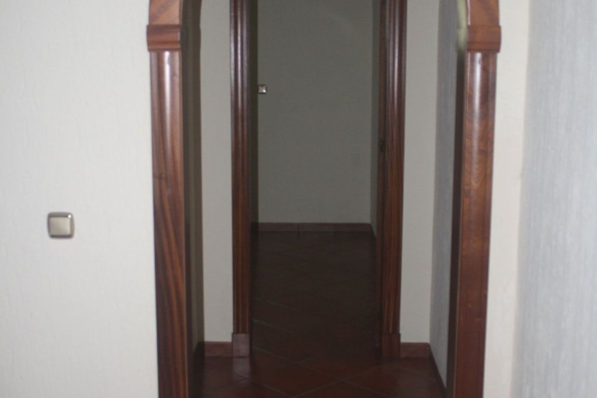 Gang binnen een huis in Torrevieja, met een boogdeur en toegang tot andere kamers.
