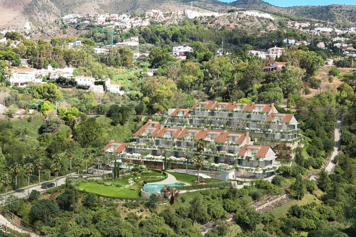 Luchtfoto van een modern complex omringd door groen met schilderachtige heuvels in Benalmádena, Costa del Sol.