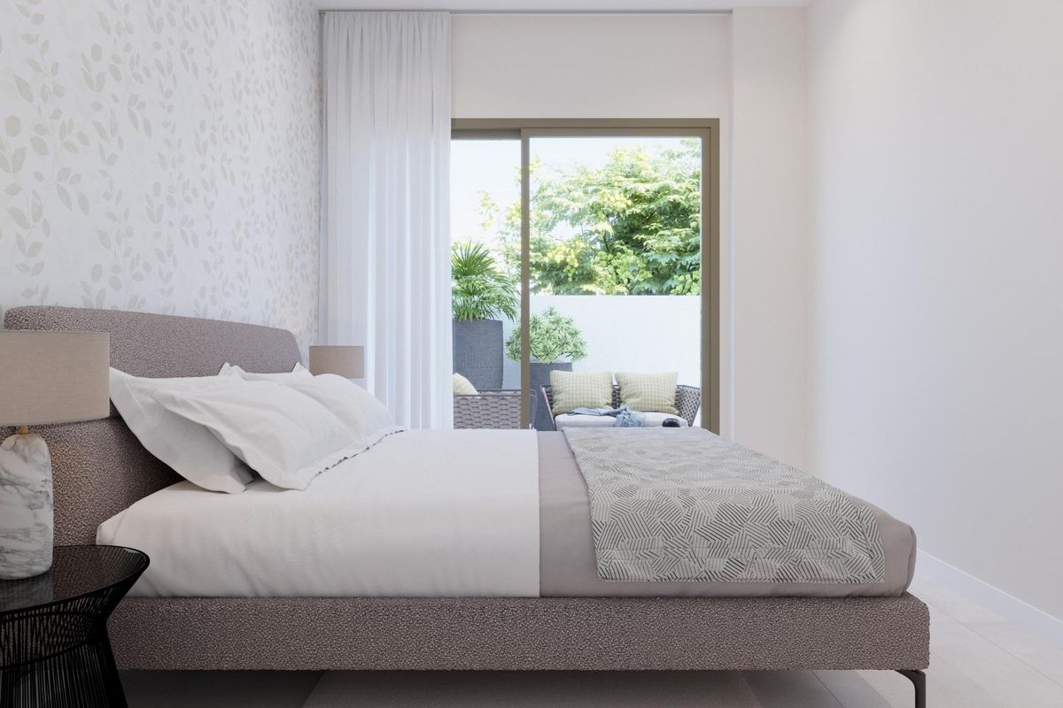 Stijlvolle slaapkamer met moderne decor en uitzicht op de tuin in een 3-slaapkamer appartement op de begane grond.