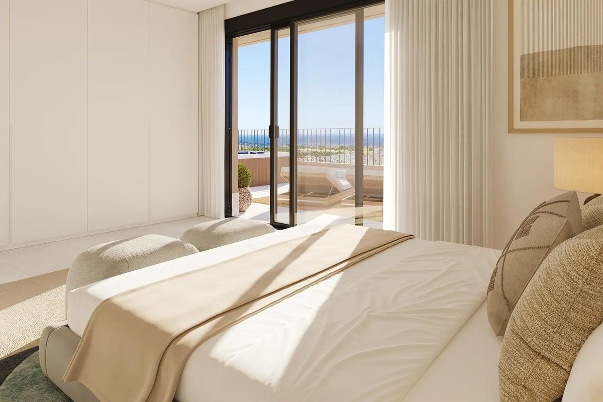 Gezellige slaapkamer van een penthouse in Fuengirola, met een comfortabel bed en toegang tot een privébalkon met uitzicht.