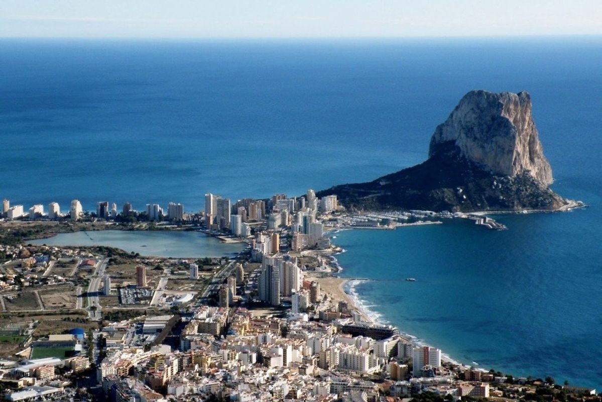 Luchtview van Calpe, met helder water en de iconische rots, die de schoonheid van de locatie toont.