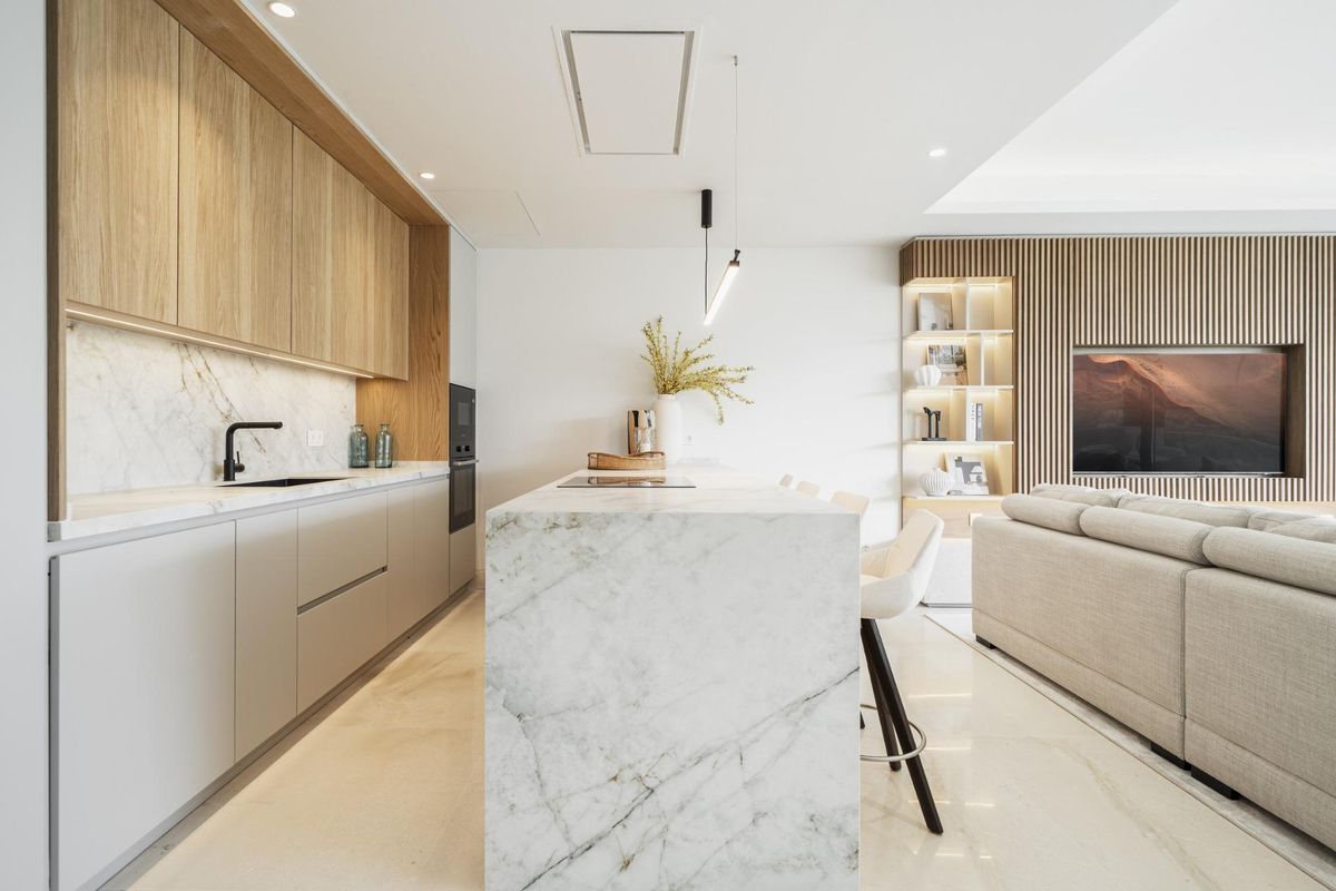Moderne keuken met strakke kasten en marmeren werkbladen in een luxe appartement in Marbella.