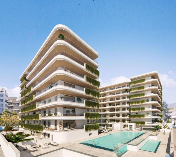Buitenzicht op een modern appartementencomplex met zwembaden, gelegen in Fuengirola, Costa del Sol.