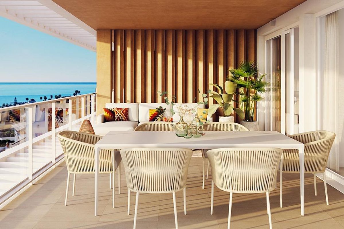 Elegant terras met eetset en decoratieve planten, met uitzicht op de oceaan in een appartement in San Roque.