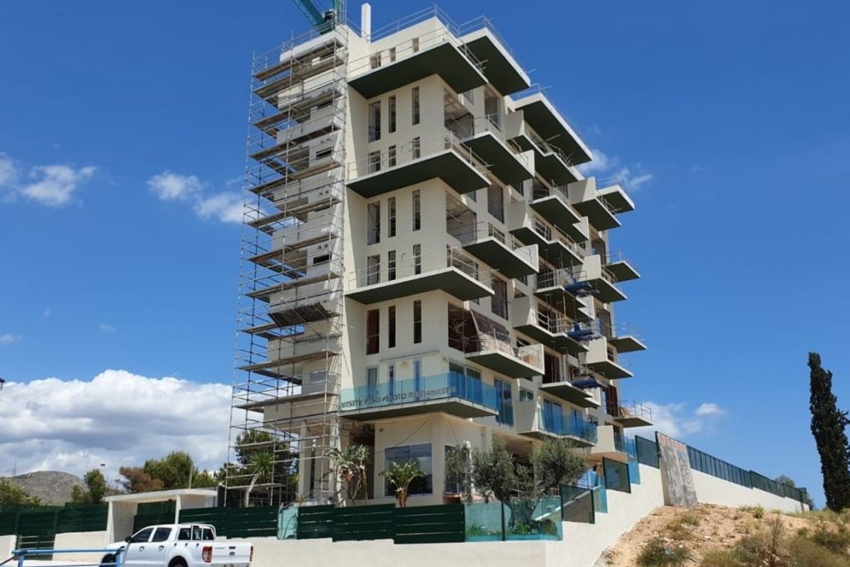 Buitenkant van een modern 1-slaapkamer appartement gebouw in Finestrat, Costa Blanca. Onder constructie met steiger.