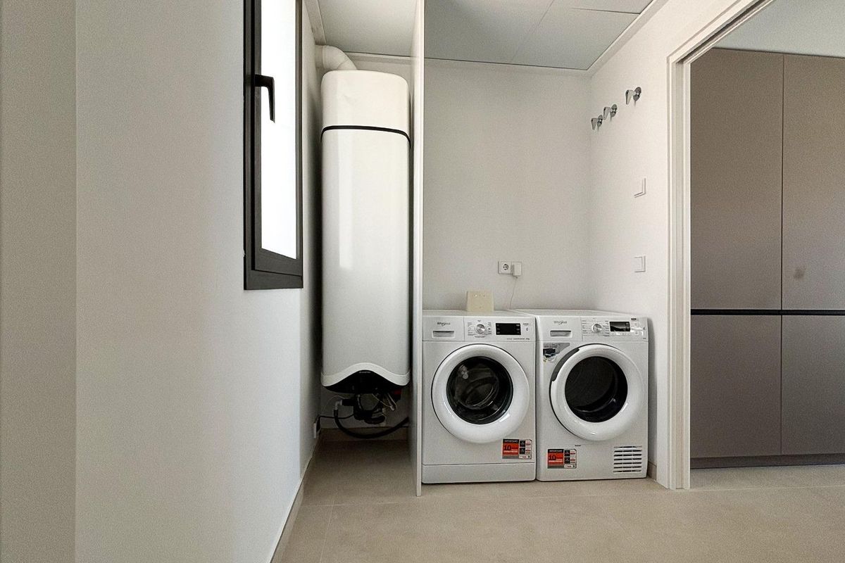 Wasruimte met wasmachine en droger in moderne villa in Polop, Costa Blanca Noord, Spanje.