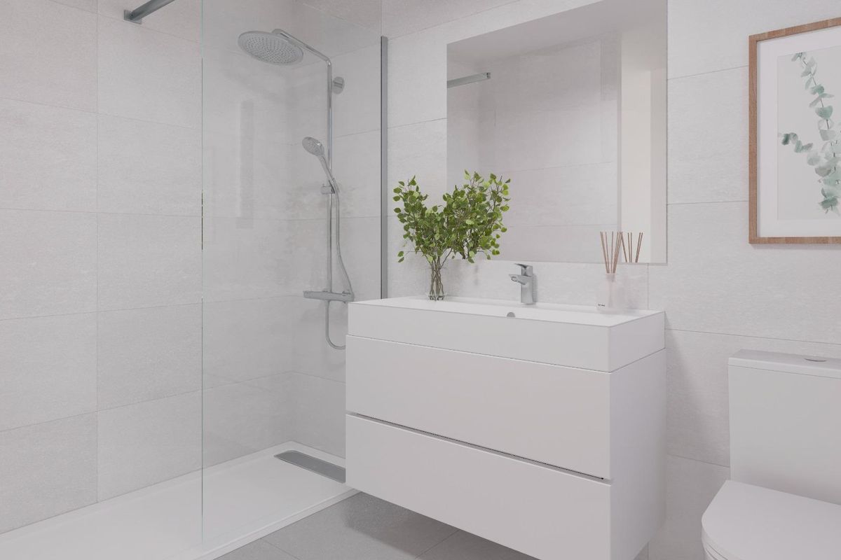 Moderne badkamer met douche in een begane grond appartement in Estepona. Strak, minimalistisch design met witte tegels en eigentijdse armaturen.