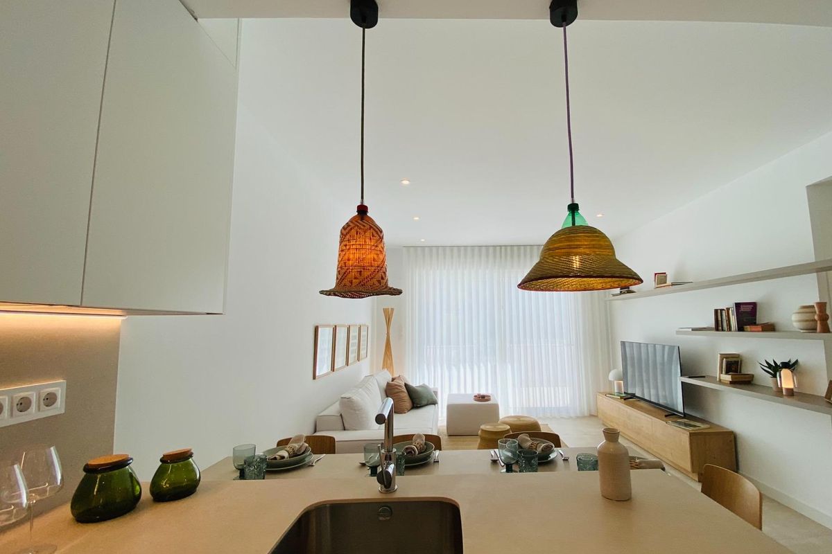 Stijlvolle keuken met decoratieve hanglampen en een ontbijthoek in een modern appartement in Pilar de La Horadada.