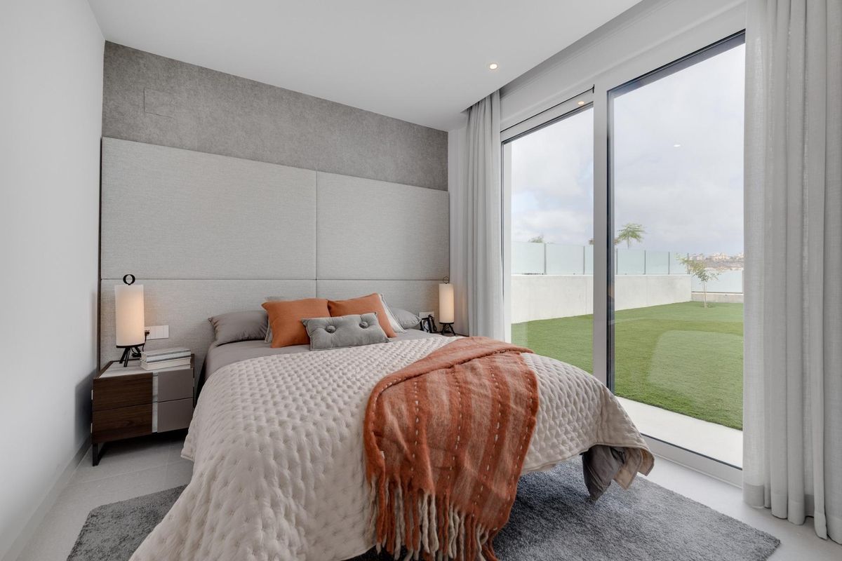 Stijlvolle slaapkamer met schuifdeuren naar een tuinzicht, onderdeel van een 3-slaapkamer villa in Mutxamel, Costa Blanca.