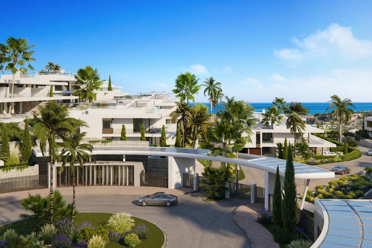 Grote ingang met palmbomen die naar luxe bungalows met zeezicht in Marbella, Costa del Sol leidt.