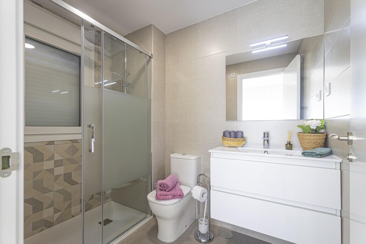 Contemporary badkamer met een glazen douche en stijlvolle armaturen in een appartement in La Manga del Mar Menor.