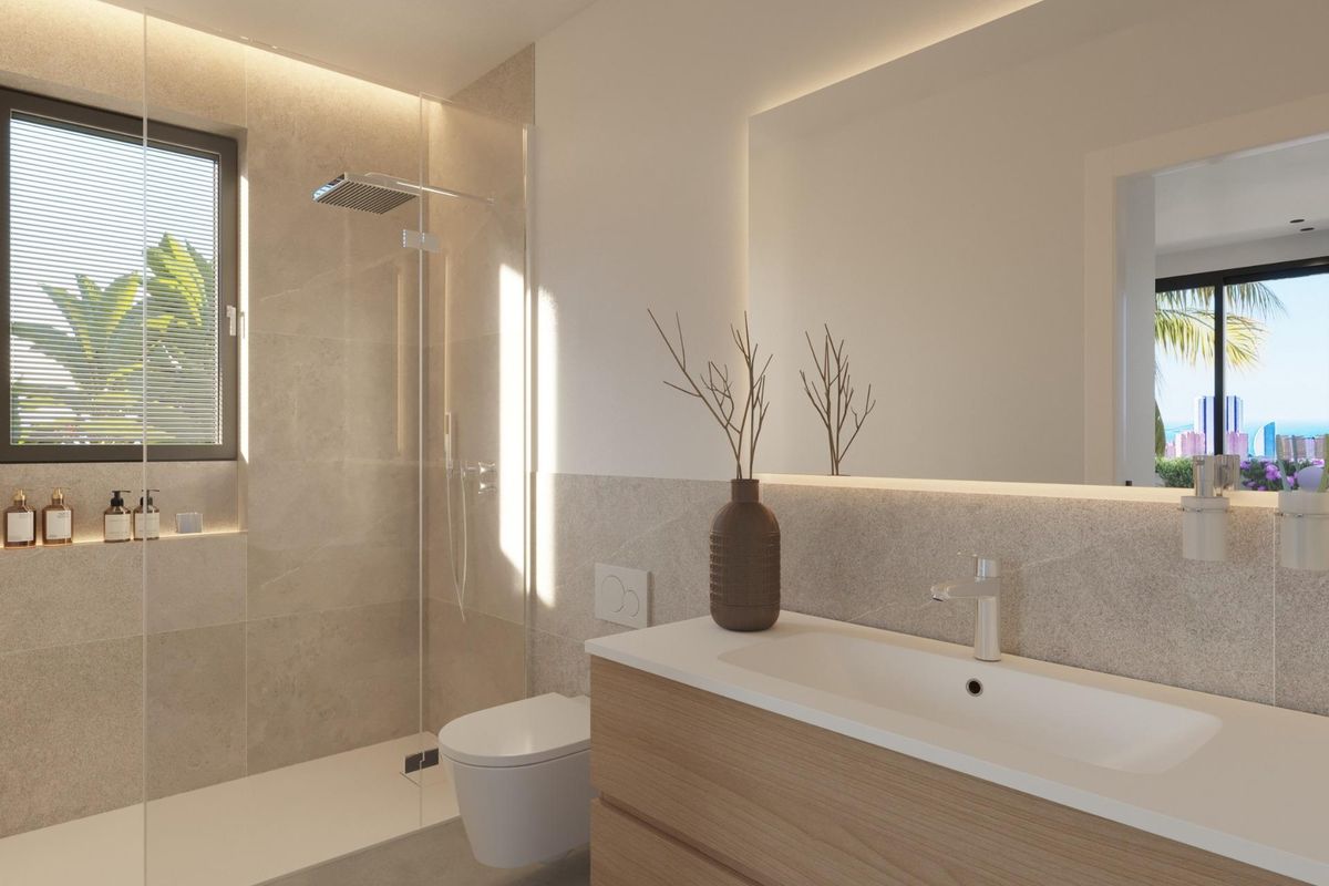 Moderne badkamer in een villa in Finestrat, benadrukt door stijlvolle armaturen en een ruime douche.