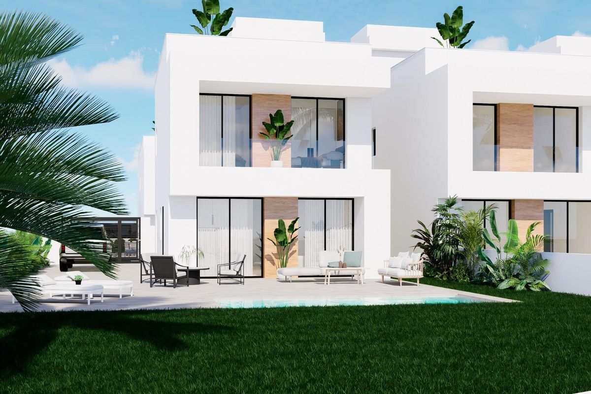 Zijaanzicht van een eigentijdse townhouse in Orihuela Costa, met de tuin en het zwembadgebied.