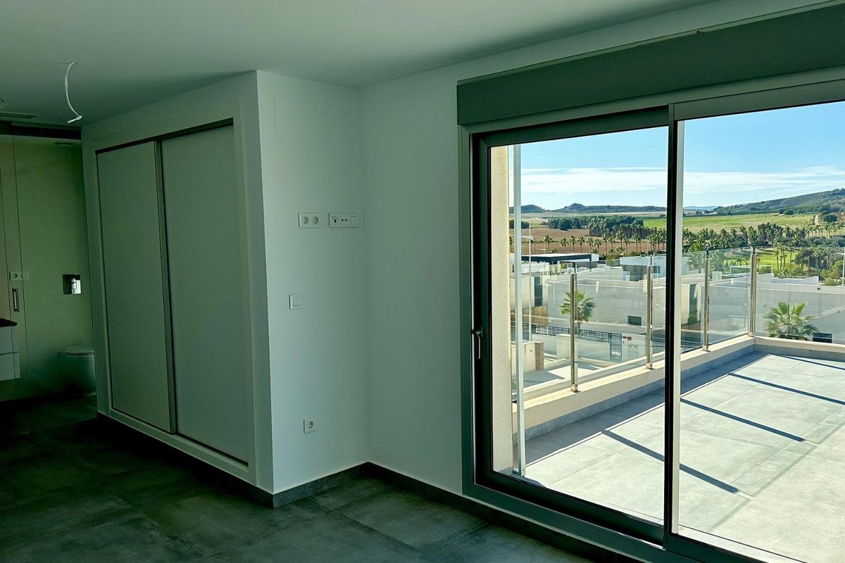 Slaapkamer met groot raam en prachtig uitzicht, met toegang tot het terras in een moderne 4-slaapkamer villa in Algorfa, Costa Blanca Zuid.