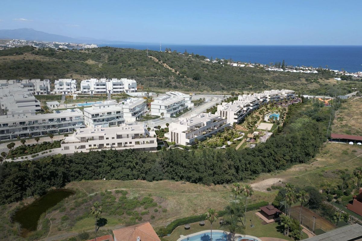 Luchtfoto van moderne appartementen in Estepona, Costa del Sol, met groene ruimtes en zwembaden.