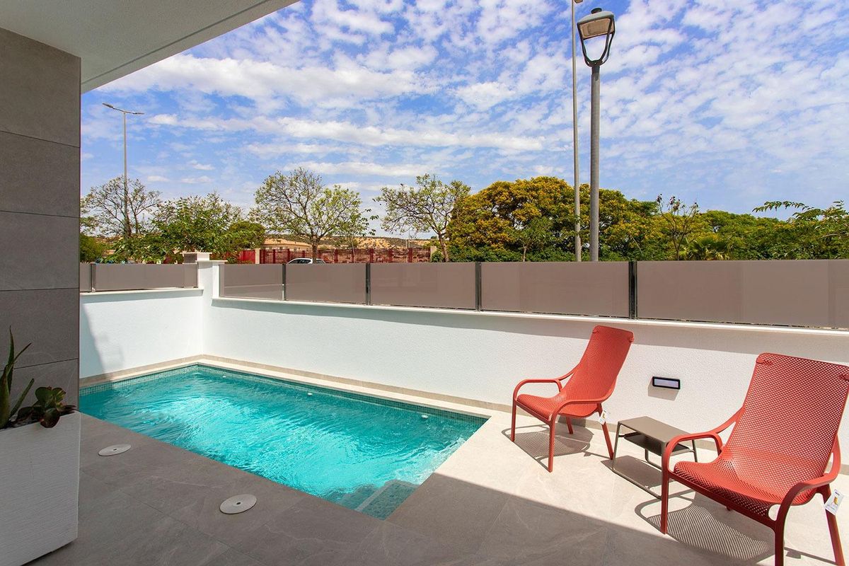 Zonnig uitzicht op een zithoek bij het zwembad van een townhouse in Sucina, met blauwe lucht.