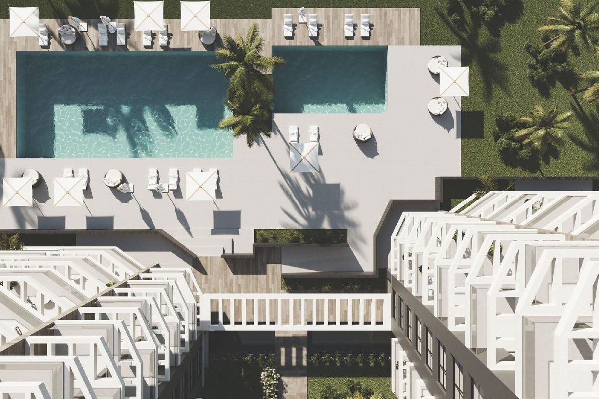 Luchtfoto van het zwembadgebied omringd door palmbomen en ligbedden in Calpe, Spanje.