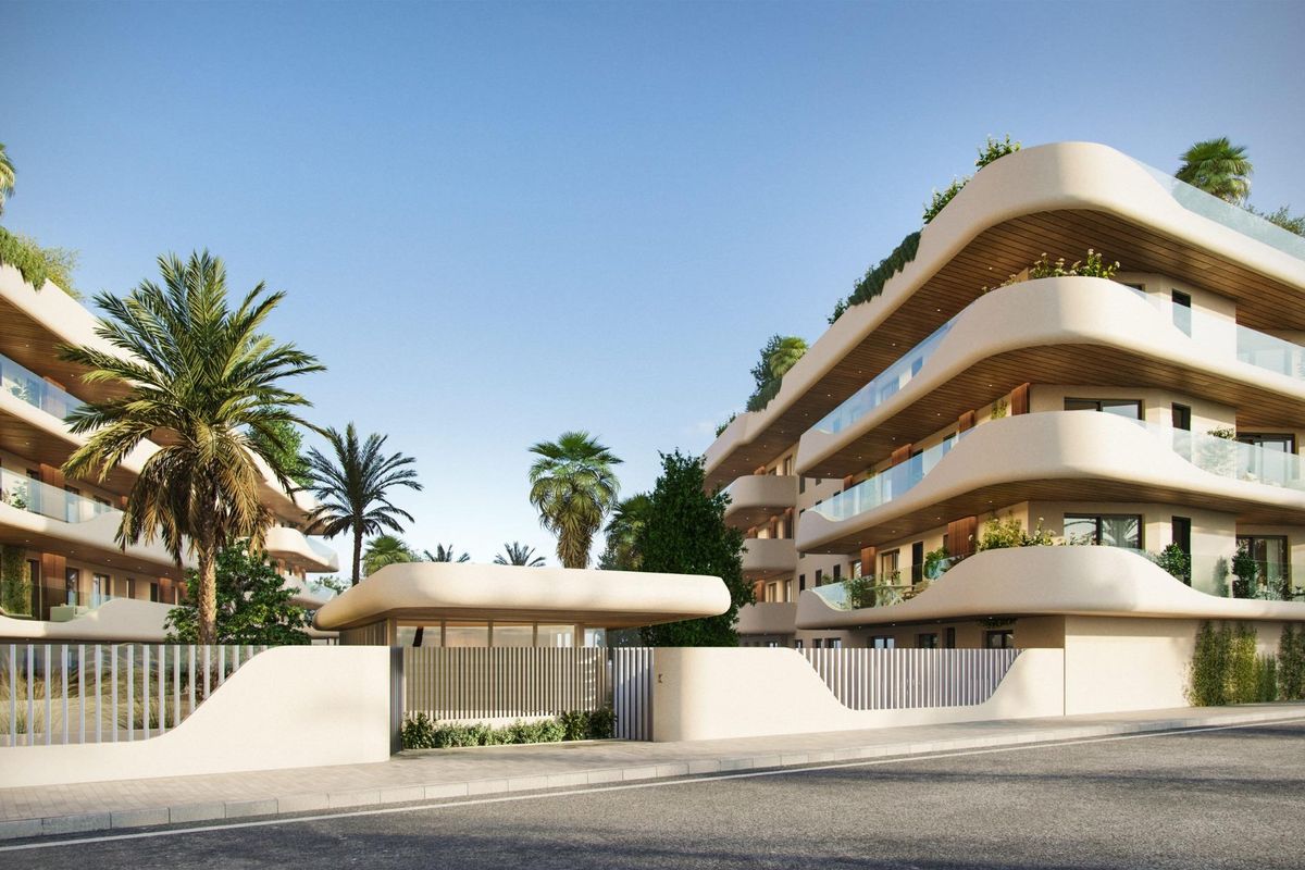 Stijlvolle ingang van een appartementencomplex omgeven door groen, gelegen in Marbella, Costa del Sol.