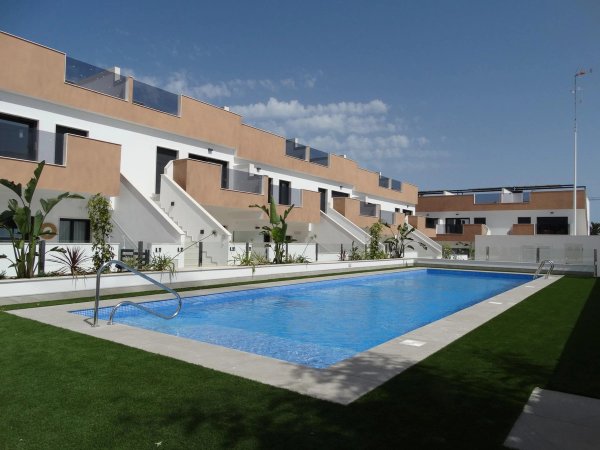 Modern apartment complex with a pool in Pilar de La Horadada, featuring well-maintained landscaping.