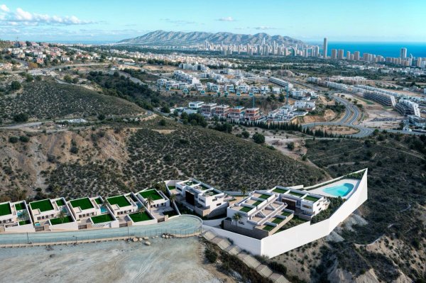 Aerial view of a modern property layout in Finestrat, Costa Blanca, showcasing hills and city skyline.